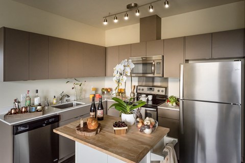 a kitchen with stainless steel appliances and a wooden counter top